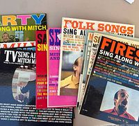 Stack of Mitch Miller Sing Along LP jackets showing multiple titles