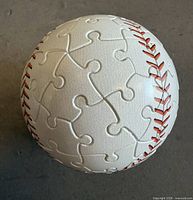 Top view of resin puzzle baseball showing jigsaw piece construction and red stitching