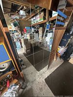 Full view of rectangular grid mirror leaning against shelving