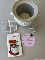 Freeze bowl, dasher, drive assembly, instruction booklet, quick start guide disc displayed together