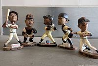 Group shot of all five bobbleheads showing poses and sponsor plaques
