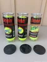 Front view of three sealed Penn Championship tennis ball cans with lids