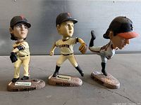 Group shot of three San Francisco Giants bobbleheads: two Tim Lincecum variants and one Matt Cain