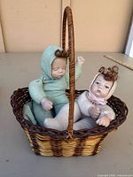 Basket containing two sand-filled cloth porcelain dolls