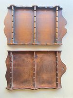 Front view of both wooden spoon racks showing spoon slots and scalloped edges