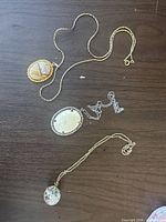 Overview of three pendant necklaces on table