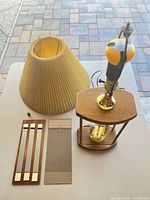 Lamp disassembled showing shade, frame, etched glass panel, mirror panel set and bulb assembly