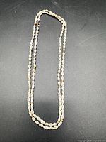 Full view of 34" pearl necklace laid out on surface