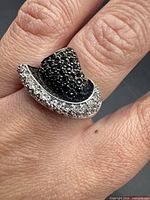 Ring top view showing pavé black stones and clear stone rim