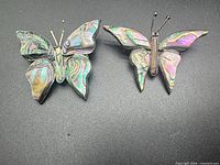 Front view of two abalone inlay sterling butterfly brooches