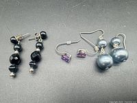 All three pairs of earrings laid out on black background