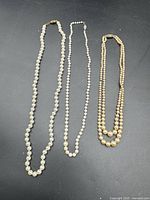 Three pearl necklaces laid out side by side