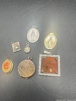 All seven assorted pendants laid out on black surface