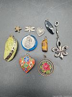 Overview of ten assorted pendants on black background