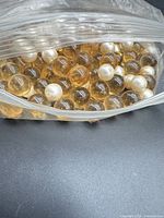 Bag of amber and white beads partially open
