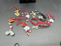Group view of twelve jade charms and cord bracelets