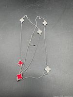 Necklace showing red enamel clover faces and clasp