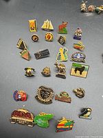 Overview of entire lot of pins spread on dark surface