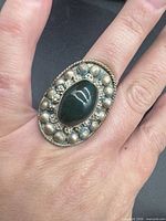 Top view showing green cabochon, beaded halo and rope border