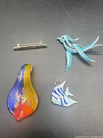 Group view of four jewellery items on black surface