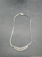 Full view of necklace displaying chain and rhinestone leaf centerpiece