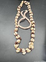 Two necklaces laid out on dark surface