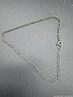Full view of figaro chain bracelet laid flat