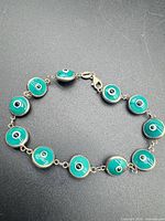 Full view of evil eye bracelet laid flat showing all eleven round charms