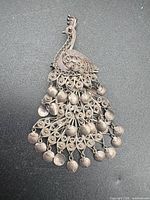 Front view of sterling silver filigree peacock pendant-brooch