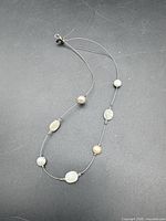 Full view of sterling silver wire choker with seven coin pearls