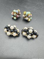 Two pairs of bead cluster button covers on flat surface