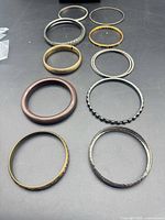 Twelve assorted bangles laid out