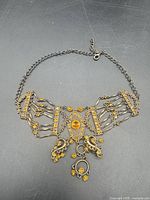 Full view of filigree Victorian revival adjustable jewelry piece laid flat
