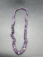 Full view of the amethyst chip bead necklace laid out in loop