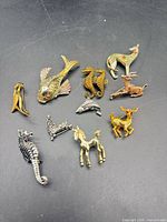 All ten brooches laid out on black background