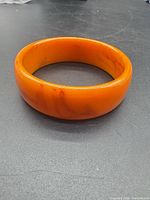 Top view of orange Bakelite bangle showing color and surface