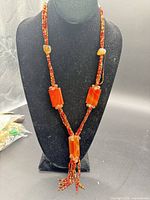 Full view of carnelian and seed bead necklace on display bust