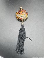 Full view of pendant showing disc and tassel