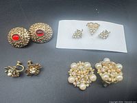 All four pairs of earrings displayed on black background