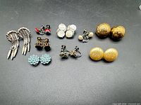 All eight pairs of earrings arranged on black background