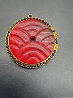 Front view showing carved red lucite and stone-set border