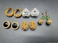 All five pairs of earrings laid out on black background