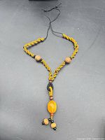 Full view adjustable macramé necklace on black background