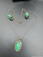 Entire set: necklace and two earrings displayed on surface