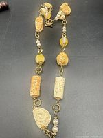 Full view of long necklace layout showing bead variety and clasp