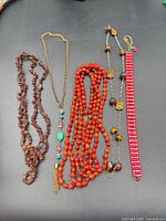 Overview of five jewellery pieces laid out on black background