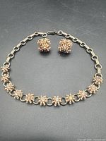 Full view of necklace and earrings laid flat