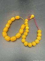 Both yellow bead bracelets laid flat showing bead shapes and colors