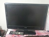Front view of Viore TV on stand with remote