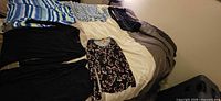 Six long sleeve tops laid out on bed showing overall variety